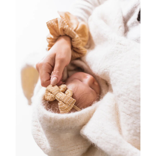 Hand hält einen kleinen Teddy, passend zum Little Bow Headband in Vanilla