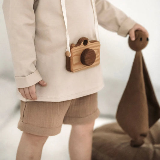 Holzkamera um den Hals eines Kindes, kombiniert mit dem Beigefarbenen Langarmshirt