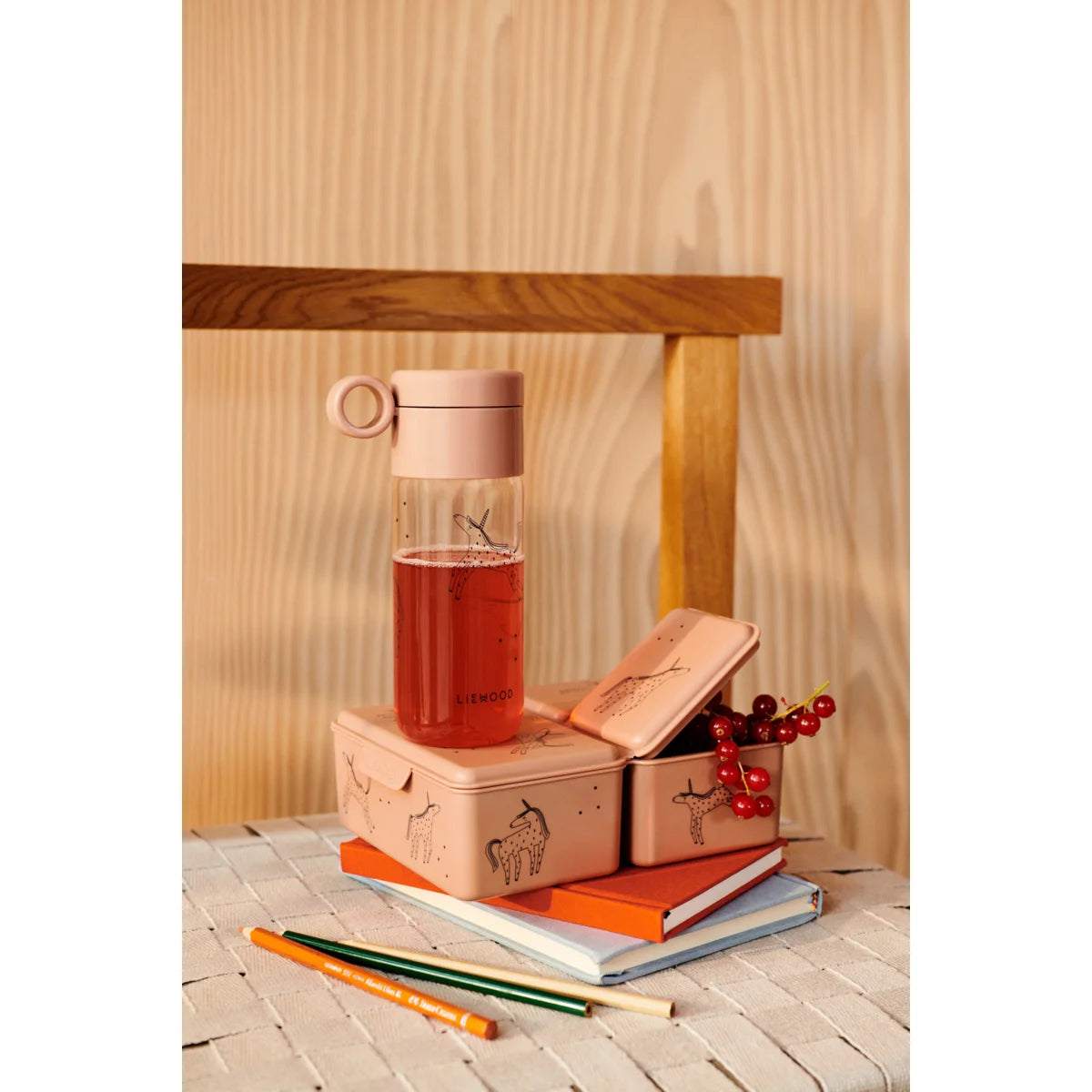 Eine Glasflasche mit roter Flüssigkeit auf gestapelten Büchern und Kisten