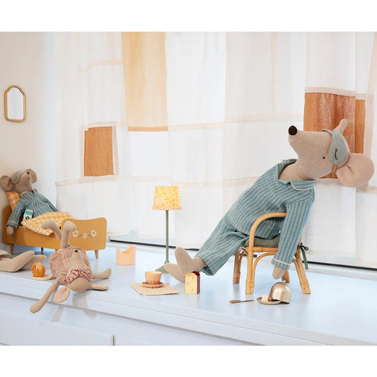 Plüschmaus im Schlafanzug entspannend in einem Holzstuhl. Maxi-Maus im Schlafanzug