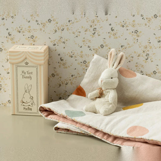 Maileg My First Bunny in Off white sitting with fabric and a box