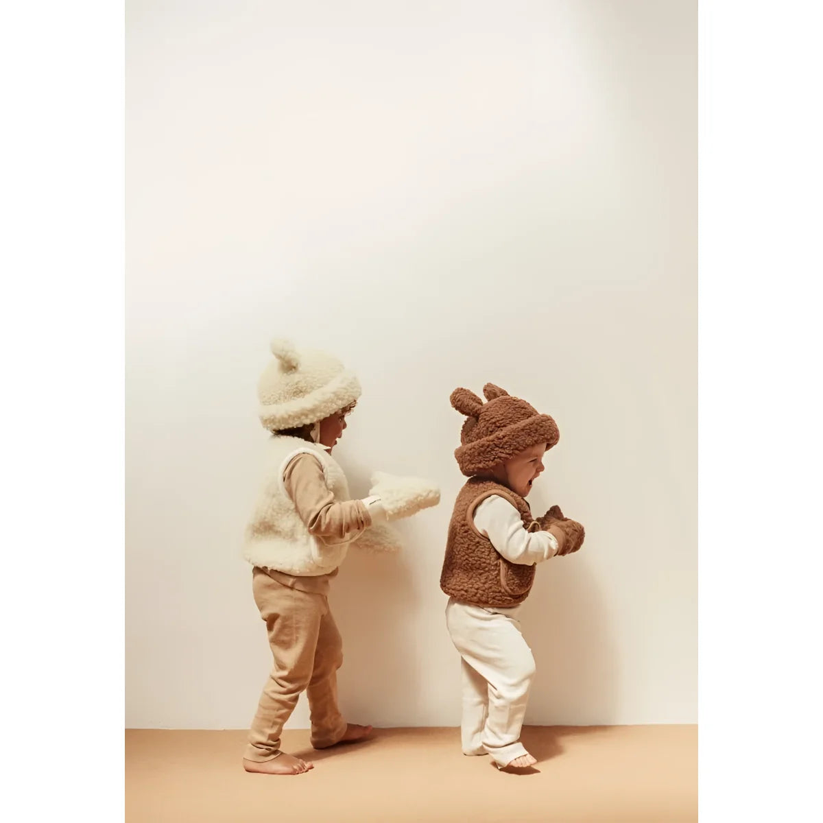 Zwei Kinder in Fleece-Animal-Westen und Mützen mit dem Merino Hat Bruno