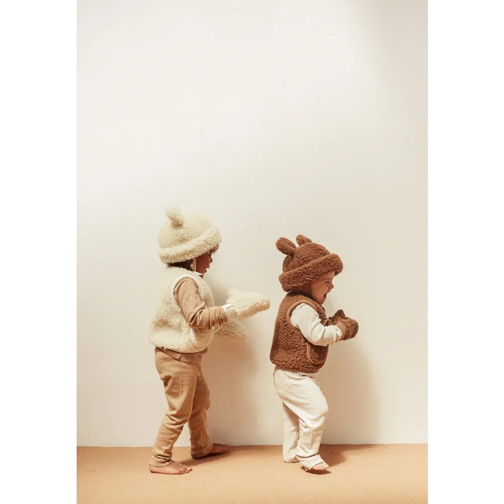 Zwei Kinder in Fleece-Animal-Westen und Mützen mit dem Merino Hat Bruno