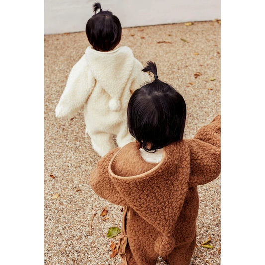 Zwei Kinder in übergroßen, gemütlichen Mänteln mit dem Merino Snugglesuit von Bruno