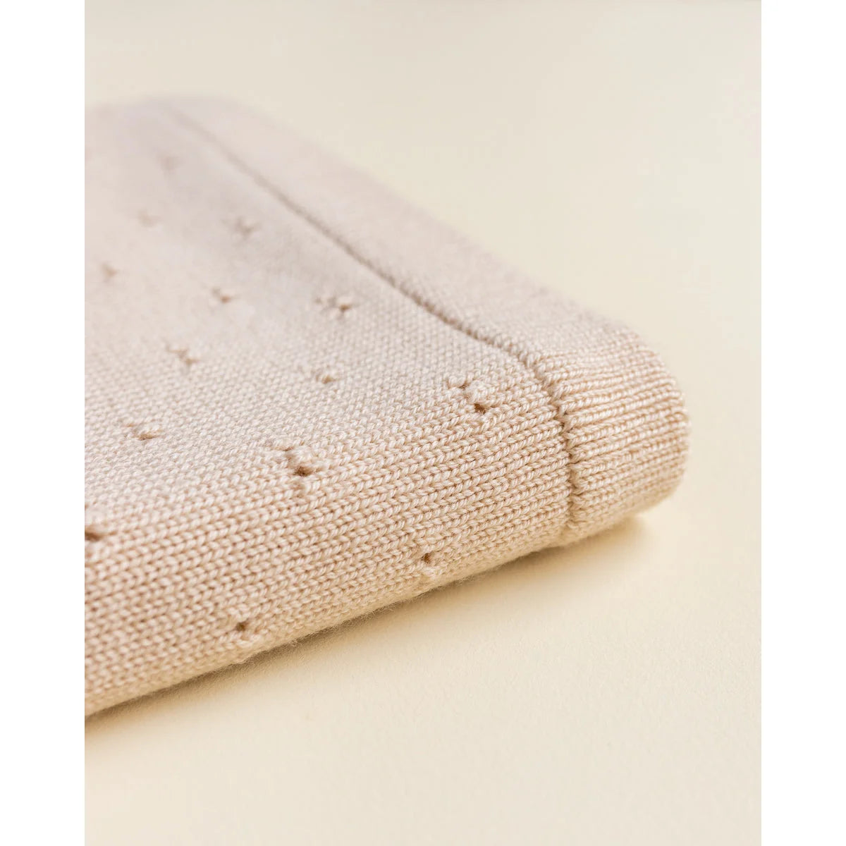 Gefalteter, cremefarbener Strickstoff mit kleinen sternartigen Mustern, Merino Strickdecke Bibi