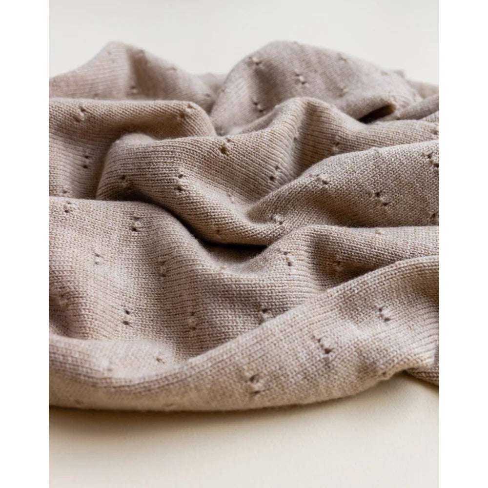 Crumpled beige Merino Strickdecke Bibi mit kleinen Löchern auf der Oberfläche