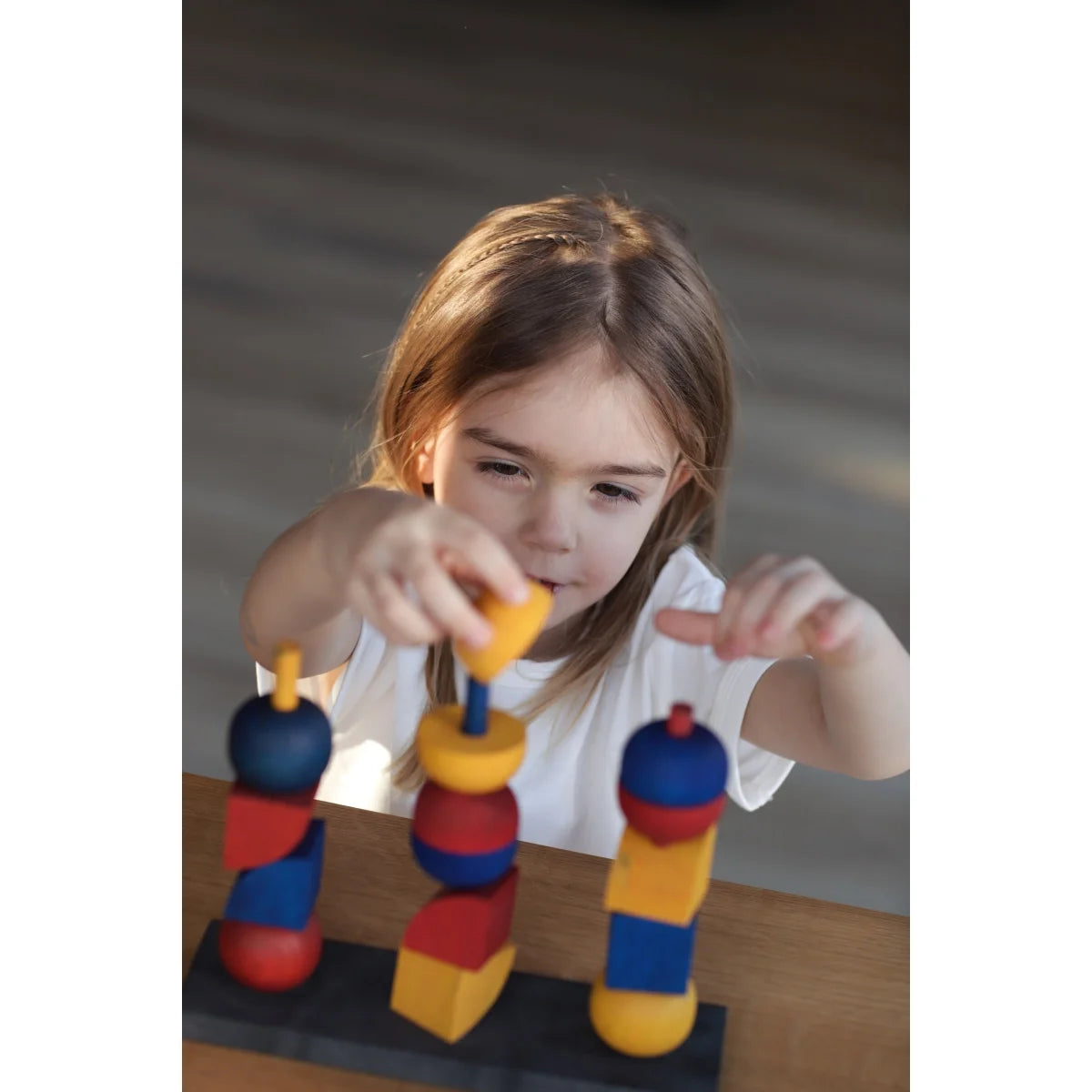 Modern stacking toy y mit bunten holzklötzen auf schwarzer basis als nachhaltiges baby- & kinderprodukt