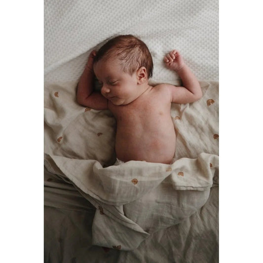 Schlafendes Neugeborenes in einer weichen, cremefarbenen Decke von Mulltuch Rainbow