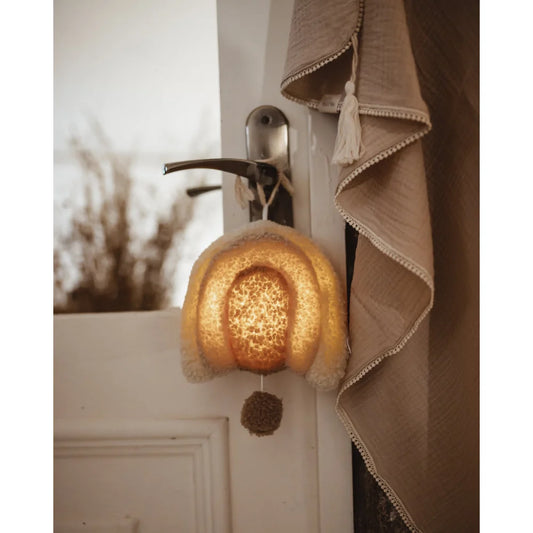 Illuminiertes Glockenlicht hängt an Türgriff der Musikspieluhr Regenbogen