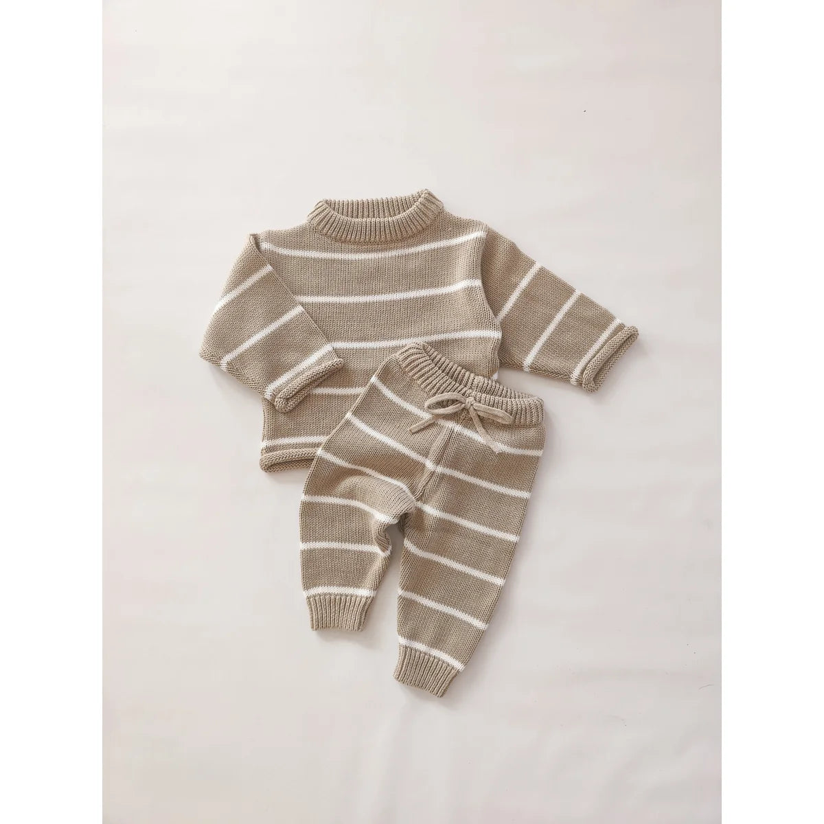 Beige und weiße gestreifte Strickbabykleidung mit Pullover und Hose