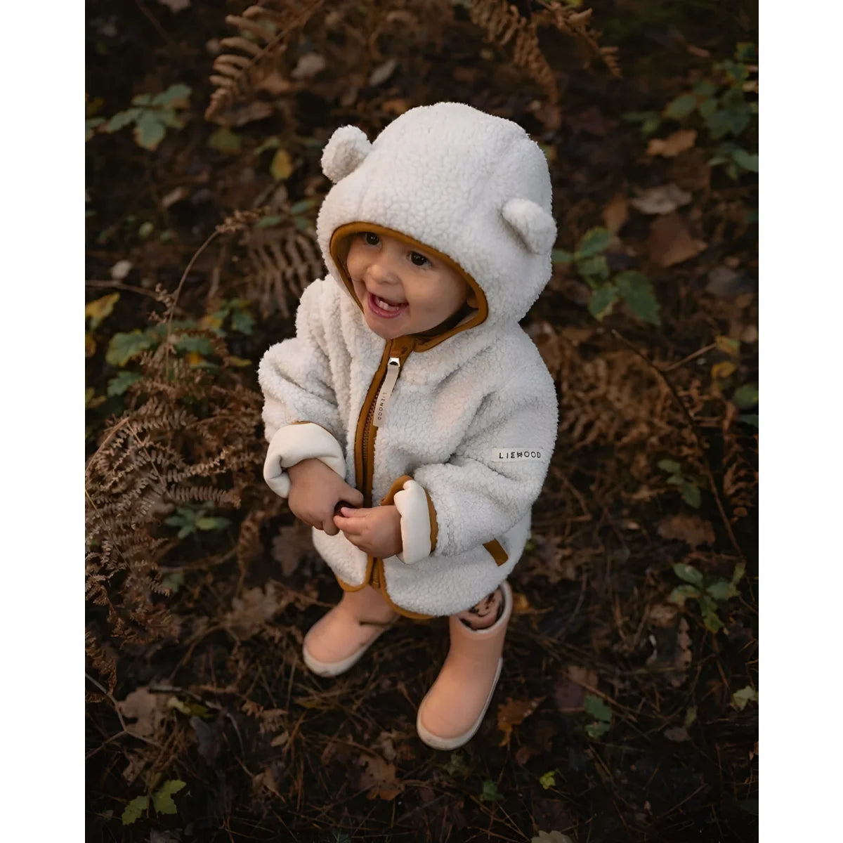 Gemütlicher weißer Teddy-Pullover mit passender Mütze und Stiefeln in Sandkaramell