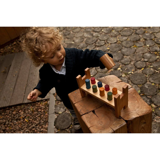 Wooden rainbow pound-a-peg toy with colorful cylindrical blocks on natural wood base for ökologische baby- & kinderprodukte
