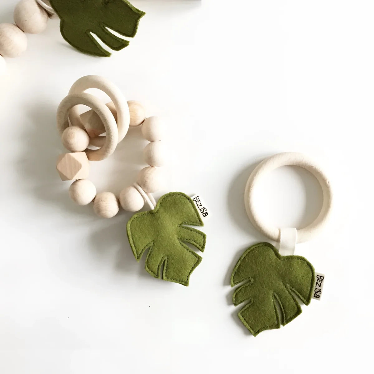 Holzbeißringe mit grünen Filz-Monstera-Blatt-Dekorationen von Rassel Leaves
