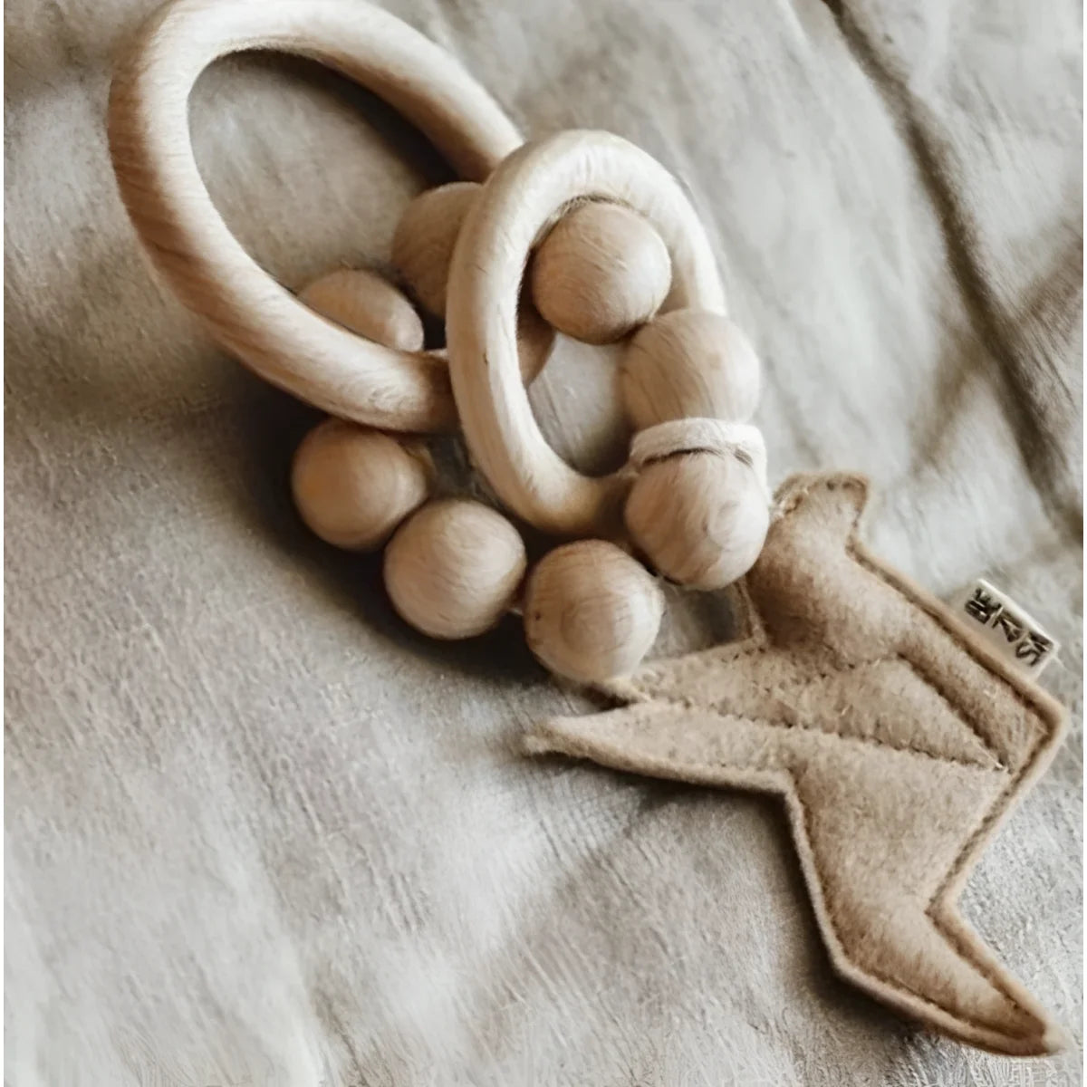 Holz Baby Rassel mit Filzblitz für das Produkt Rassel Vogel Mauve