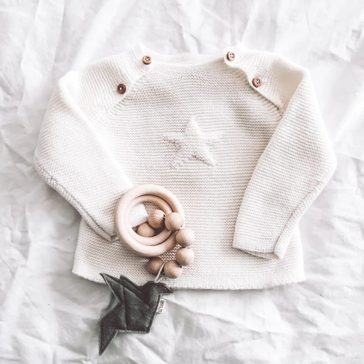 Weißer Strickbaby-Pullover mit Sternmuster und Schulterknöpfen, Rassel Vogel Pistache Grün