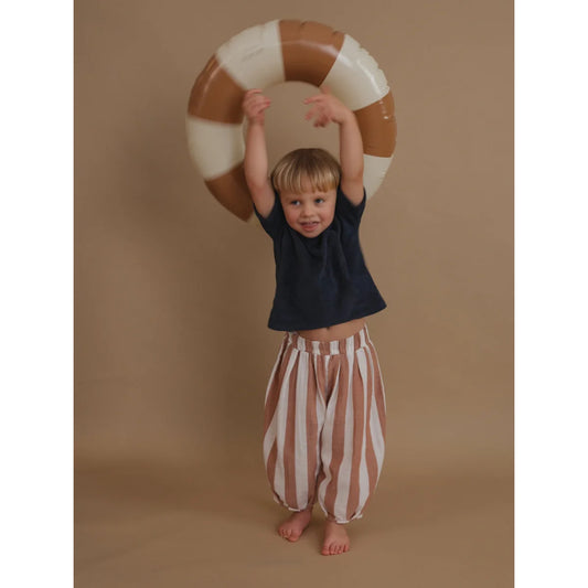 Kind mit aufblasbarem Ring in Resort Pants mit Sardinenstreifen