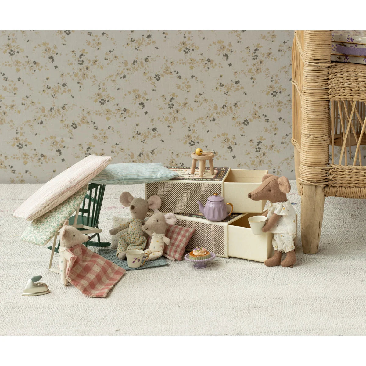 Ein dunkler grüner schaukelstuhl maus neben einer lavendelfarbenen teekanne mit golddeckel im dollhouse für ökologische baby- & kinderprodukte