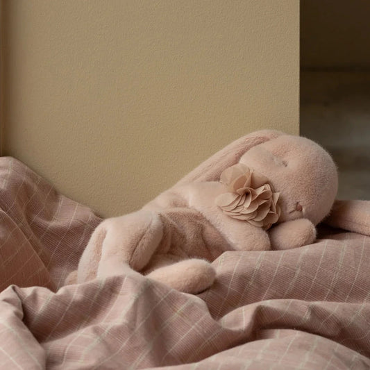 Maileg sleeping plush rabbit, small in Powder with a flower collar on pink bedding