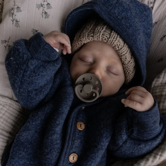 Schlafendes Baby in blauer Jacke mit Schnuller Moon Phase und Mütze