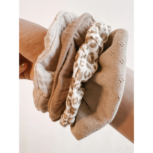 Haufen von Scrunchies in verschiedenen neutralen Tönen und Mustern - Scrunchie Musselin