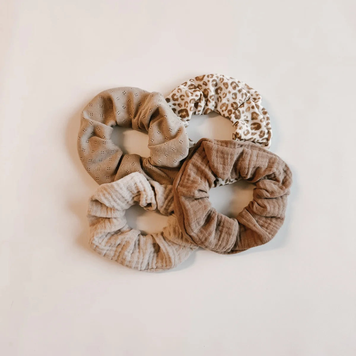 Kollektion aus Stoff-Haargummis in neutralen Erdtönen und Mustern für Scrunchie Musselin Kakao