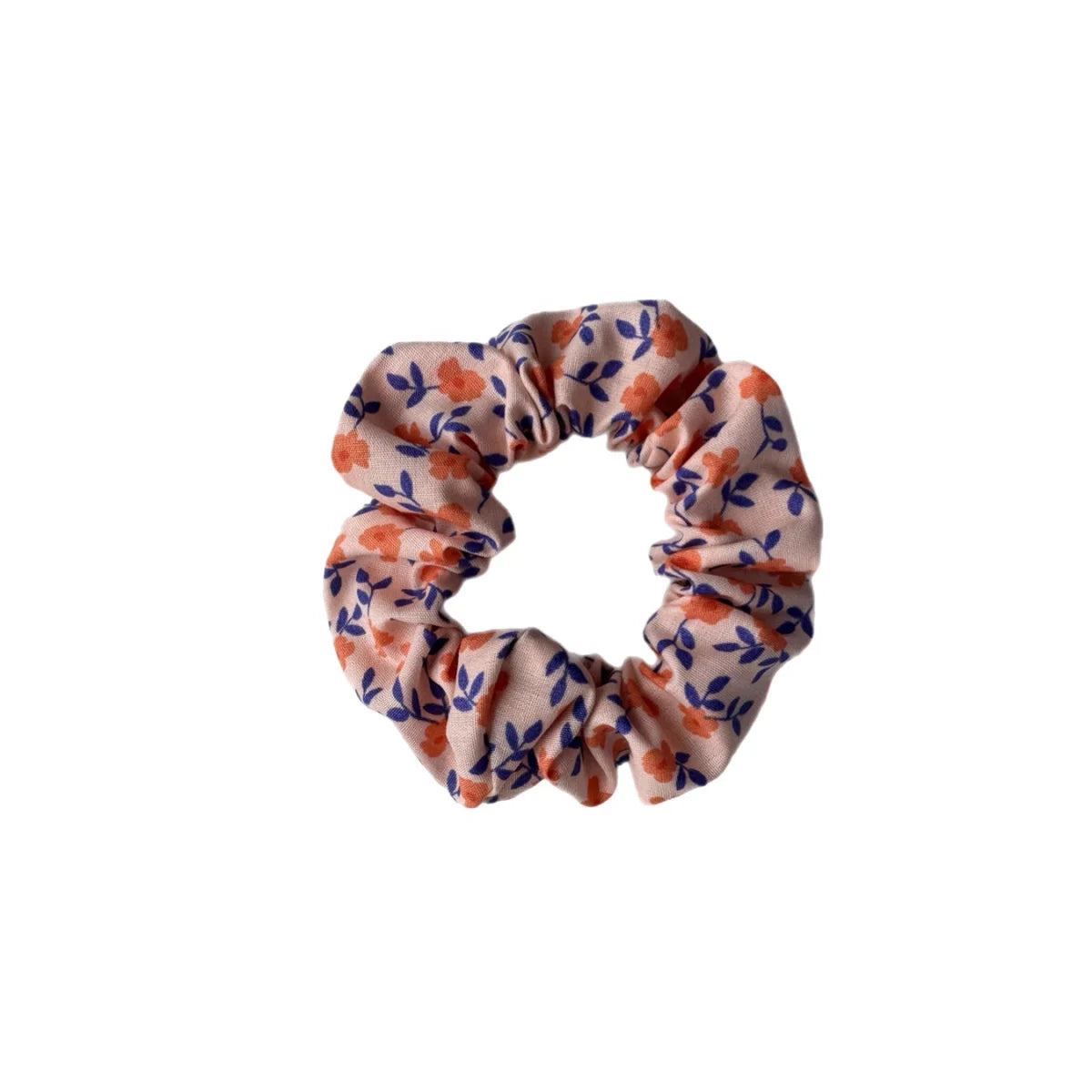 A soft pink fabric scrunchie with delicate orange flowers and navy blue leaves from Scrunchies mini + Me Blush collection