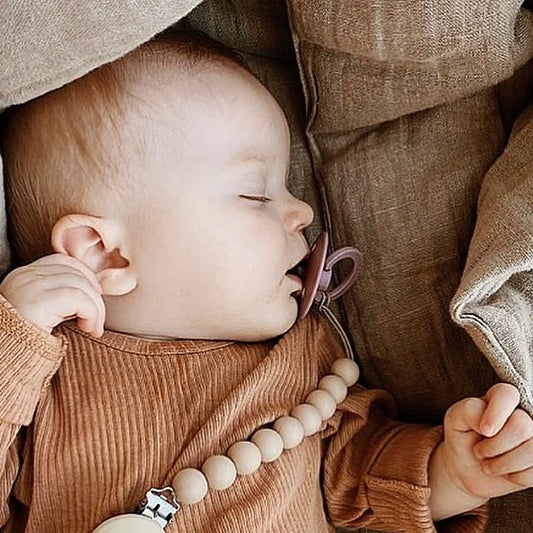 Schlafendes Baby mit Schnullerkette aus Silikon und Baumwolle, Produktname Silikon Nuggikette | Cotton