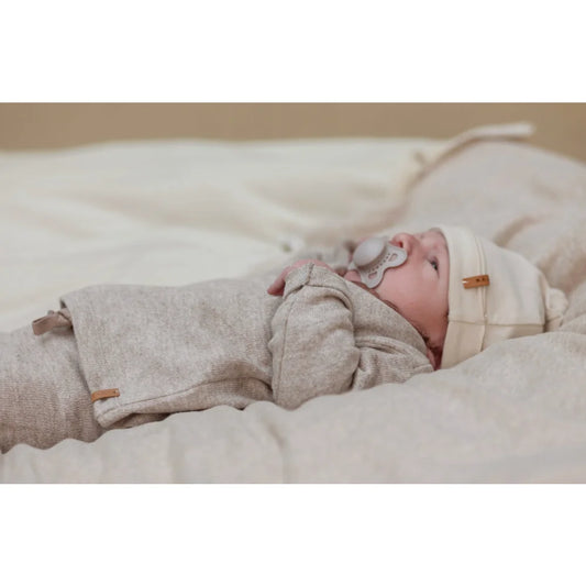 Baby im neutral gekleideten Outfit mit Pacifier, präsentiert im Soft Vest in Beige