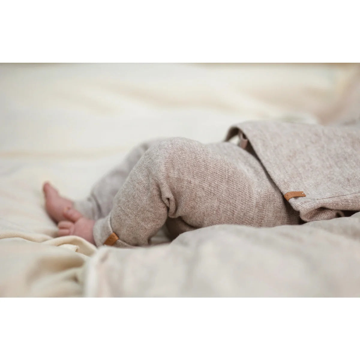 Babybeine in einer sanften Decke neben dem beigen Soft Vest