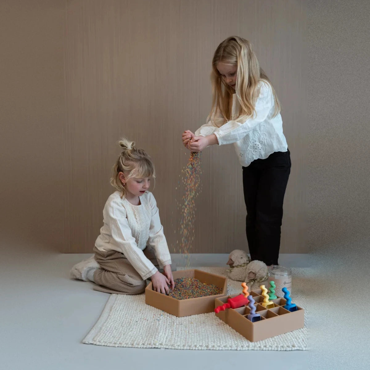 Beige sechseckige GRENNN Sortierschale mit bunten Perlen und kleinen Spielsachen