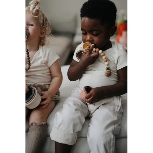 Zwei Kinder mit Schnuller und Beißring, Produkt Stapelturm Original