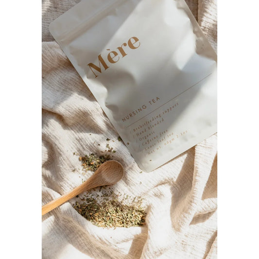 Weißes Paket mit der Aufschrift Mere, das Stilltee und lose Teeblätter zeigt