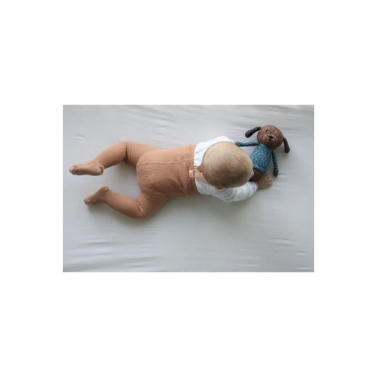 Baby Puppe mit Windel und blauem Shirt auf einer Oberfläche liegend für Strumpfhose