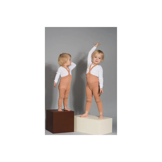 Zwei Kleinkinder in passenden orange-weißen Outfits auf Blöcken mit Strumpfhosen