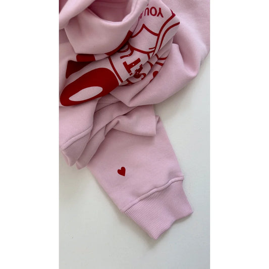 Zwei rosa Sweatshirts mit roten Love Vibes Text und Herzdesigns von Blossom