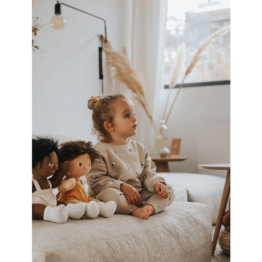 Junge mit zwei Puppen auf einem Sofa, getragenes Sweatshirt von Cottonfield