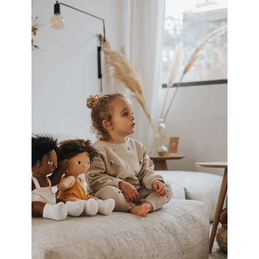 Junge mit zwei Puppen auf einem Sofa, getragenes Sweatshirt von Cottonfield