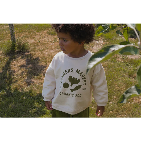 Weißes Sweatshirt mit Farmers Market Organic Zoo und Blattdesign, getragen von Kind im Freien