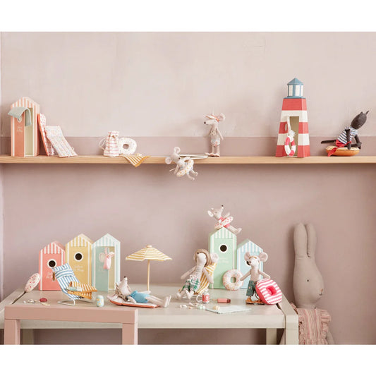 Dekorativer Regal und Tisch mit pastellfarbenen Spielzeugen und Ornamenten