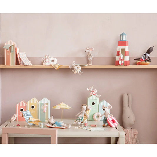 Dekorativer Regal und Tisch mit pastellfarbenen Spielzeugen und Ornamenten