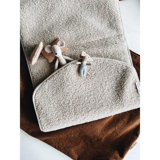 Weiches graues Handtuch mit kleinen Holzspielzeugen auf Teddy Wickelunterlage Ecru