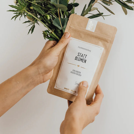 Braune Papiertüte mit Grün-Bouquet und Label Tee Statt Blumen 35g