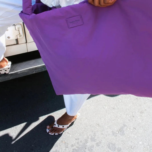 Studio Noos Textured Puffy Mom Bag in Purple mit dicken Henkeln und Label, Person trägt die Tasche