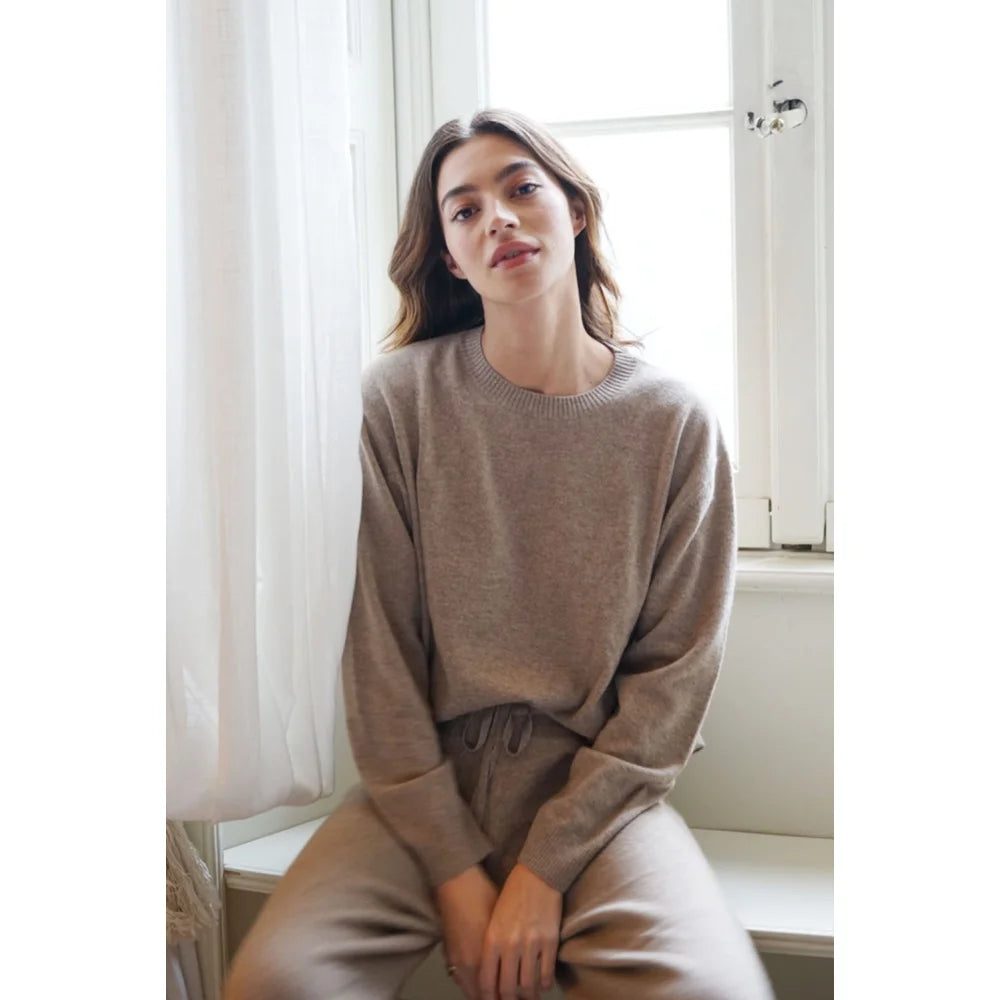 Frau trägt bequemen hellbraunen Loungewear-Set mit Cashmere Cove Crew Neck Rye