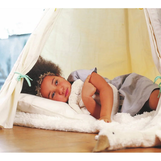 Mädchen entspannt sich im Tipi mit dem Tierkissen Elefant