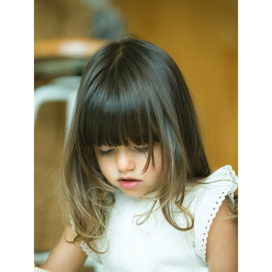 Junges Mädchen mit langen braunen Haaren trägt Top mit Ajour-Muster und Rüschenärmeln