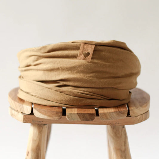 Beiger Stoffturban auf einem Holzhocker, Produkt Tragetuch Golden Pecan