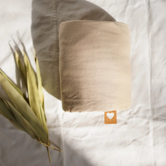 Roll mit Herzstempel-Etikett, präsentiert im Tragetuch Sand