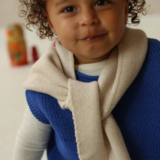 Enfant en gilet bleu, chemise blanche et jean avec le Foulard triangle Josephina Hvid en Crème