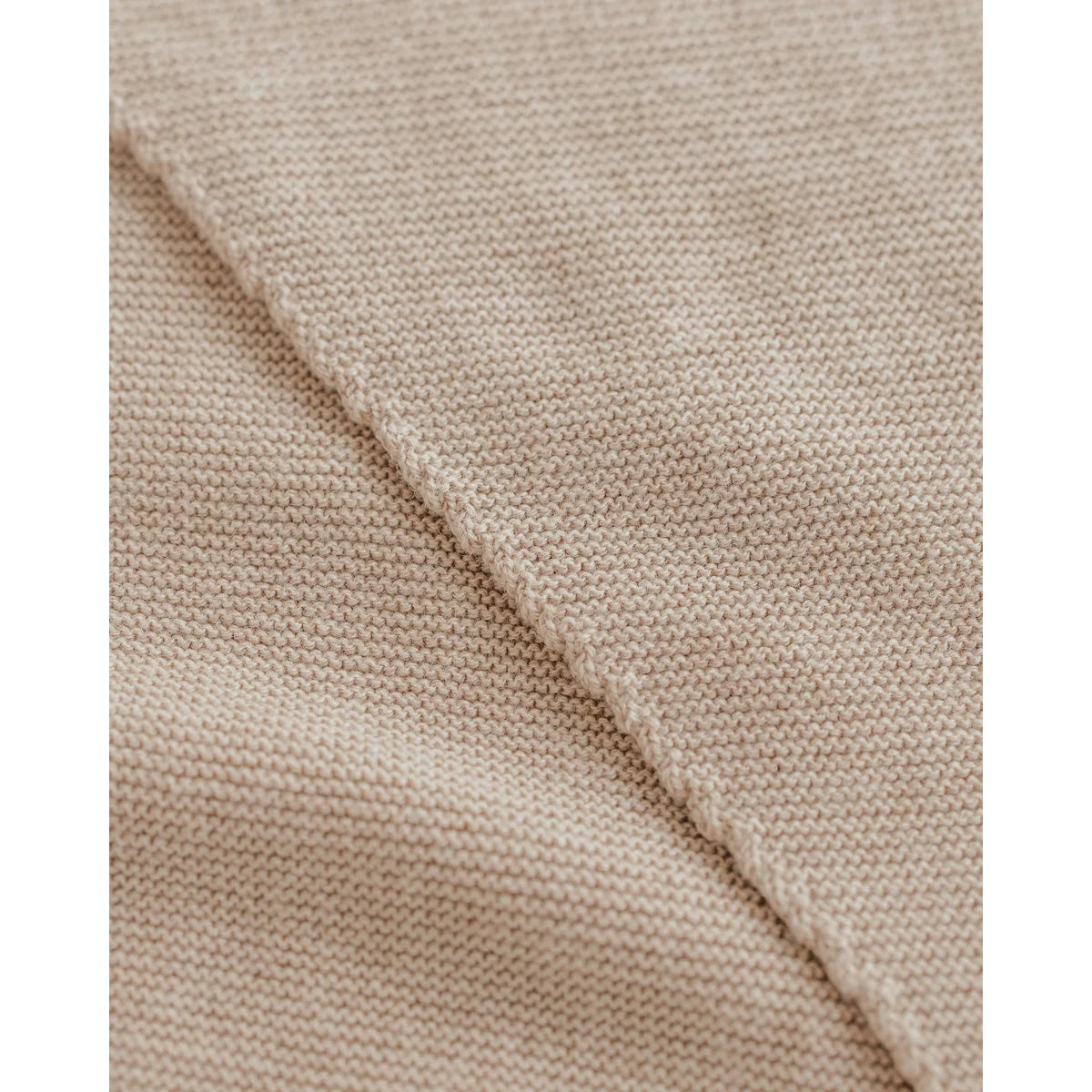 Nahaufnahme von hellbeigem, fein gestricktem Stoff beim Triangle Schal Josephina Sand